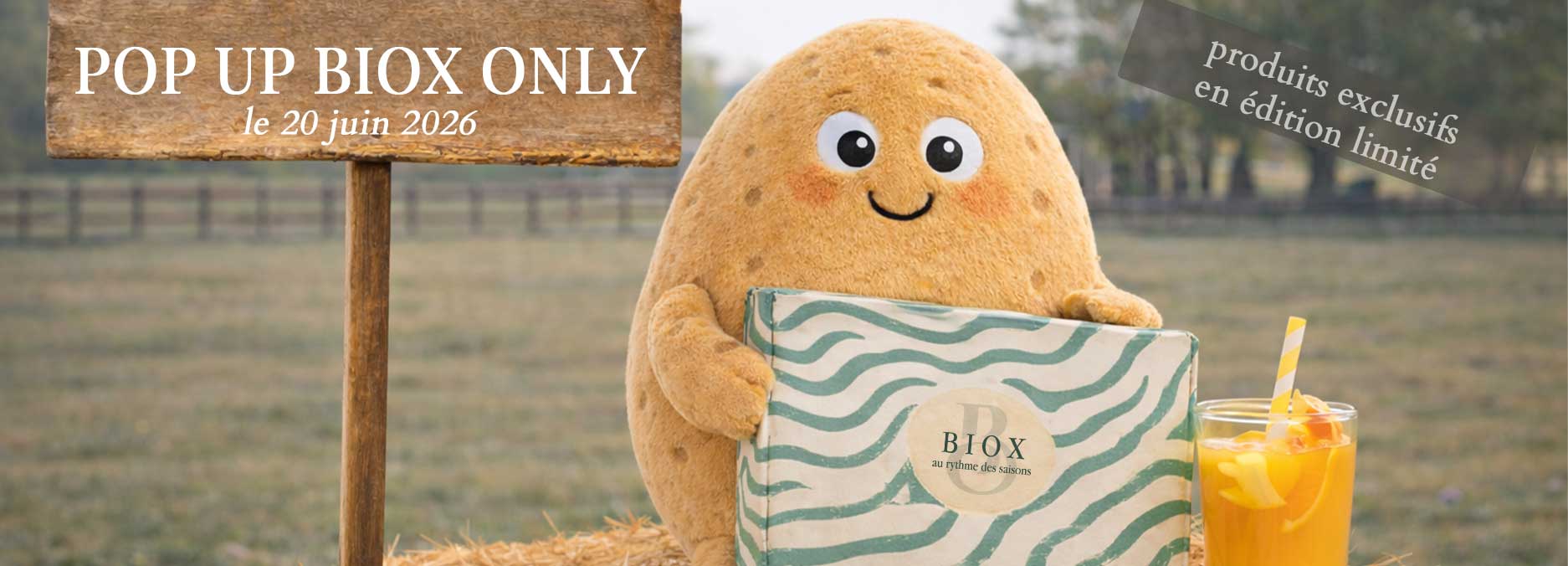 Petite Purée est assise sur une botte de foin et tient une BIOX Only dans les mains, avec un verre de jus de fruit juste à côté d'elle avec 2 indications, une écrit "POP-UP BIOX Only le 20 juin 2026", et une autre "produits exclusifs en édition limitée"